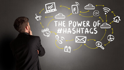businessman drawing social media icons with THE POWER OF #HASHTAGS inscription, new media concept