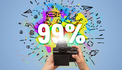Close-up of a hand holding digital camera with abstract drawing and 99% inscription