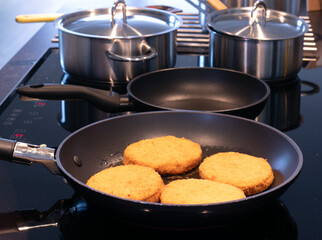 Frying pan with four burgers 
