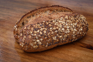 Handmade loaf of yellow wheat bread sprinkled with various cereals, close up bread, isolated. 