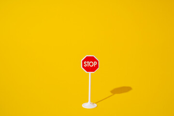 stop sign on yellow background, minimal road sign concept. - obrazy, fototapety, plakaty