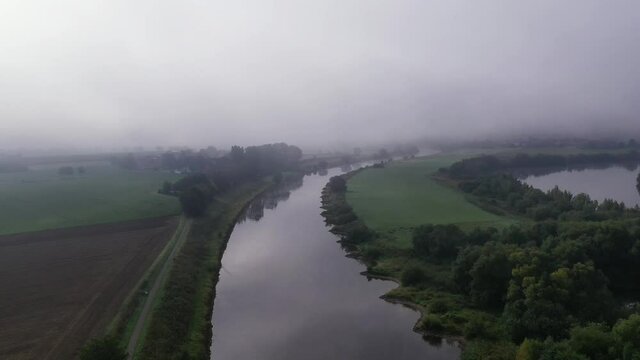 Drone flight over river in fog, Germany