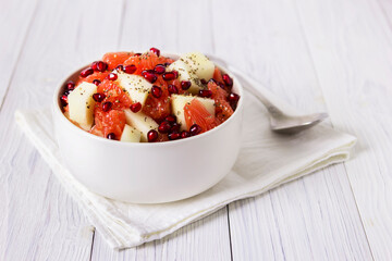 Fresh fruit salad in bowl on wooden table. Concept healthy food, diet, vegan