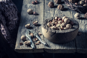 Various nuts and nutcracker on rustic wooden table