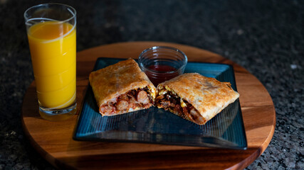 Breakfast Burrito with egg, sausage and potatoes plated on blue plate