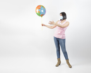 woman wearing mask in studio handling a cute air balloon