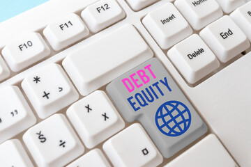 Writing note showing Debt Equity. Business concept for dividing companys total liabilities by its...
