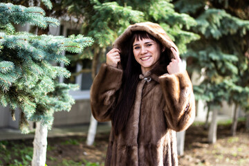 Young woman in a black mink coat on the street. 