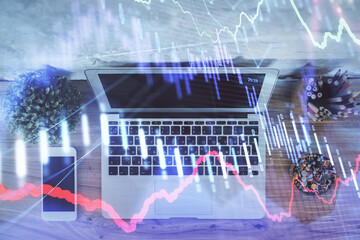 Multi exposure of financial chart drawing over table background with computer. Concept of research and analysis. Top view.