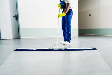 Male Janitor Cleaning Floor In Office