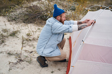 Man ties the tent mounts to the base