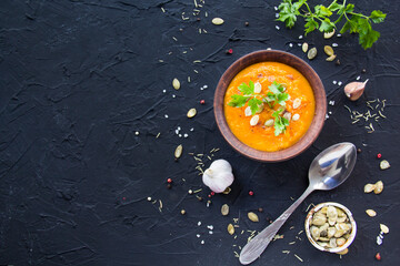 Delicious healthy pumpkin soup, herbs, and ingredients for the dish. Creative atmospheric decoration