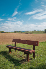 Fototapeta premium Wooden fence on a green field meadow rural landscape under a blue sunny sky