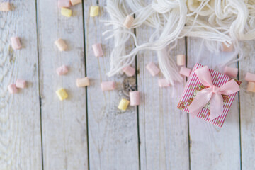 A lot of marshmallows and white scarf on a white table before christmas eve. christmas present
