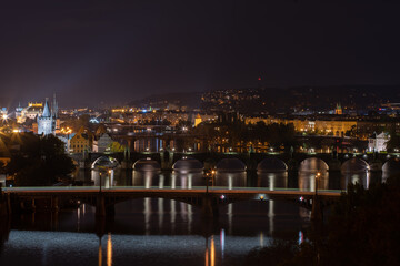 Fototapeta na wymiar panoramic view of the illuminated city of Prague and the Vltava river and the bridges on it and the light from the street lights in the city center at night