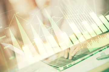 Double exposure of woman hands typing on computer and forex chart hologram drawing. Stock market...