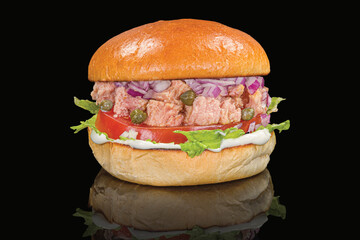 Tasty tuna fish burger with lettuce, tomatoes, onion, and sauce,