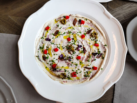 Traditional Italian dish vitello tonato - veal in tuna sauce on a plate.