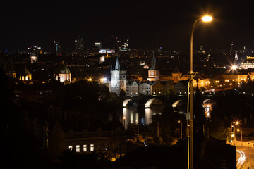 Fototapeta na wymiar panoramic view of the illuminated city of Prague and the Vltava river and the bridges on it and the light from the street lights in the city center at night