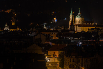 
panoramic view of the illuminated city of Prague and the Vltava river and the bridges on it and the light from the street lights in the city center at night