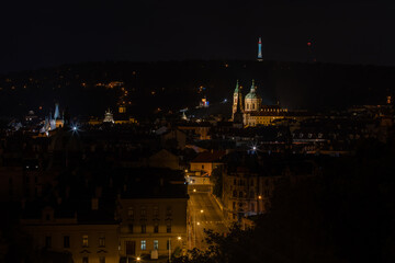 
panoramic view of the illuminated city of Prague and the Vltava river and the bridges on it and the light from the street lights in the city center at night