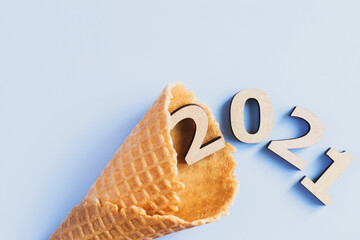 The numbers 2021 in an empty waffle cone. Christmas composition on a blue background. Christmas concept.