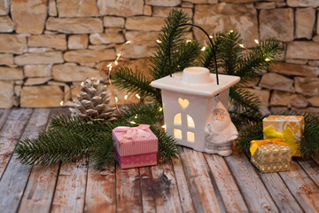 Christmas tree branches ,gift box and candlestick with candle on wooden background. Christmas decorations.
