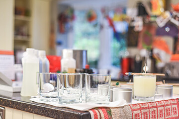 Creative occupation of candle making showing the pouring of liquid wax into jars