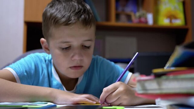 Boy Draws with Colored Pencils at Home. Home Schooling, Education Concept.