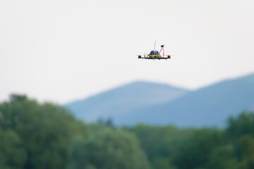 Fototapeta premium Small drone, remote control FPV racing quad copter, flying low.