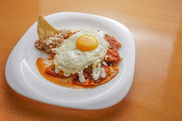 Huevos rancheros beans, tortilla chips, fried eggs, scrambled eggs with chili, comida corrida, mexican food, swooping view, overhead view


