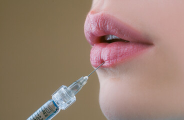 Lip augmentation. Beautiful woman's lips receiving hyaluronic acid injection. Closeup of Beautician...