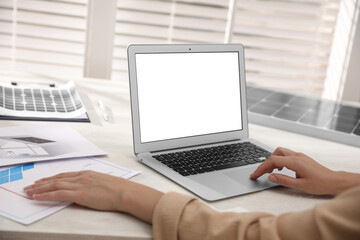 Woman working on house project with solar panels at table in office, closeup