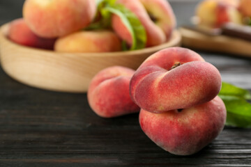 Fototapeta na wymiar Fresh ripe donut peaches on black wooden table, closeup