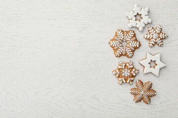 Christmas snowflake shaped gingerbread cookies on white wooden table, flat lay. Space for text