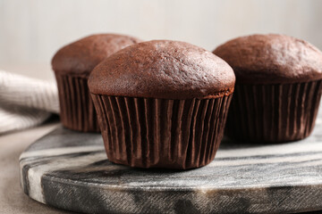 Delicious fresh chocolate cupcakes on grey marble board, closeup