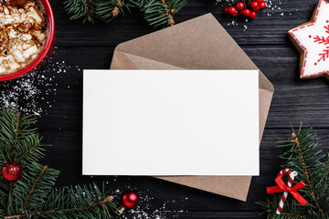 Flat lay composition with Christmas decor and blank card on black wooden table. Space for text