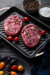 Cooking in a pan beef sirloin steak seasoned with peppercorn and salt