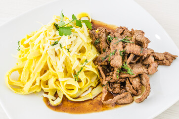 Fettuccine with huancaina sauce and pieces of lomo saltado, delicious Peruvian food