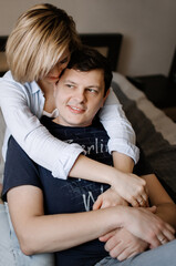 Obraz premium Man and woman hugging and having fun on the couch