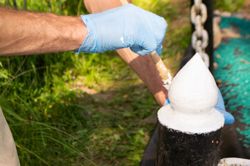 man hand with brush painting metal fence