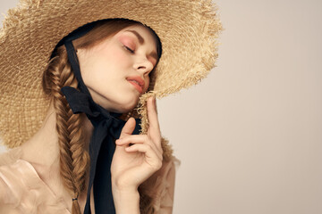 cute girl in straw hat with black ribbon and dress on beige background cropped view