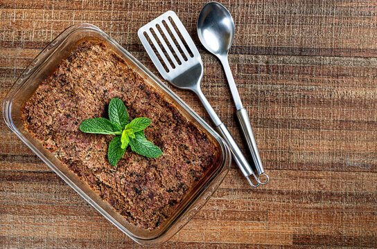 Roasted kibe in the glass bowl with mint, garlic and onion. Brazilian snack (Kibe de Forno). Space for text. Top view