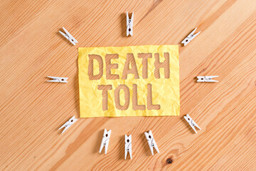 Writing note showing Death Toll. Business concept for the number of deaths resulting from a...