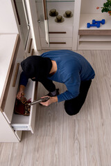 Camera view of male robber stealing things