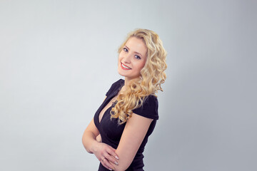 Modern blond woman in black dress smiling
