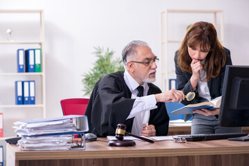 Old male judge and his young secretary in the office