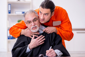 Old male judge meeting with young captive in courthouse