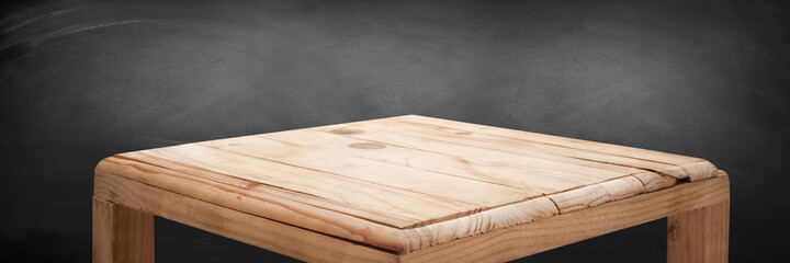 empty wooden on Chalkboard backdrop with spotlight. Wood table top. can used for display or montage your products.
