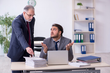 Old boss and his young assistant working in the office